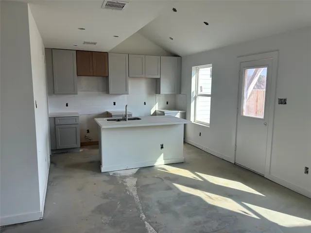 a kitchen that has a sink a window and cabinets