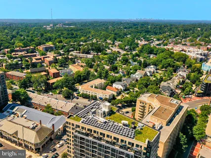 a view of tall buildings with cars parked
