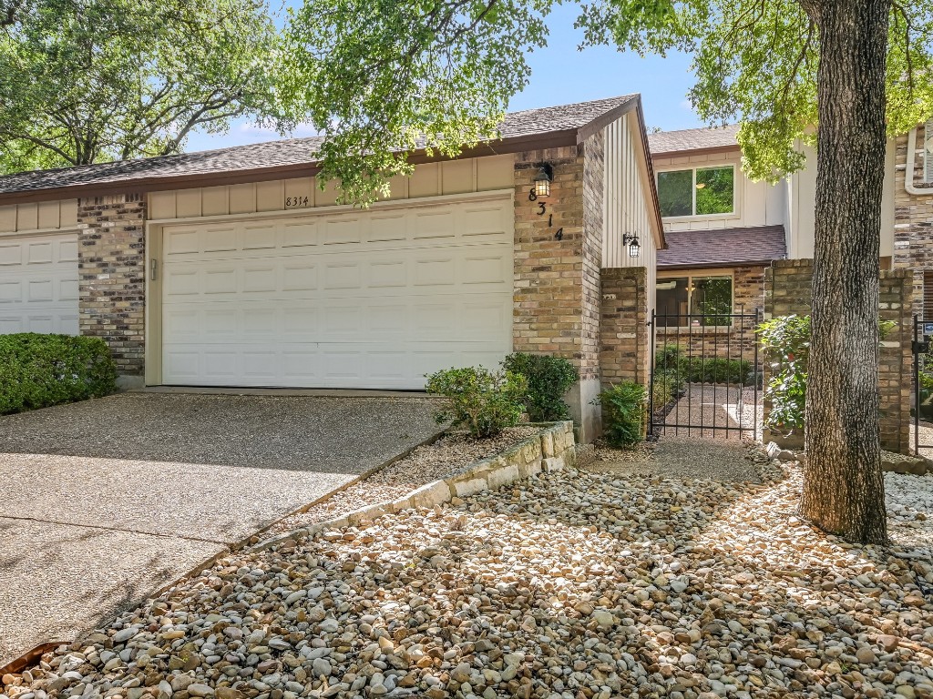 Garage featuring a gate and driveway