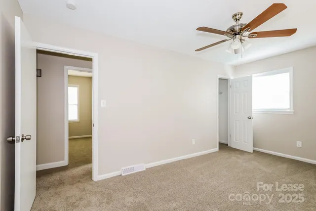 a view of a livingroom with a ceiling fan and wooden floor