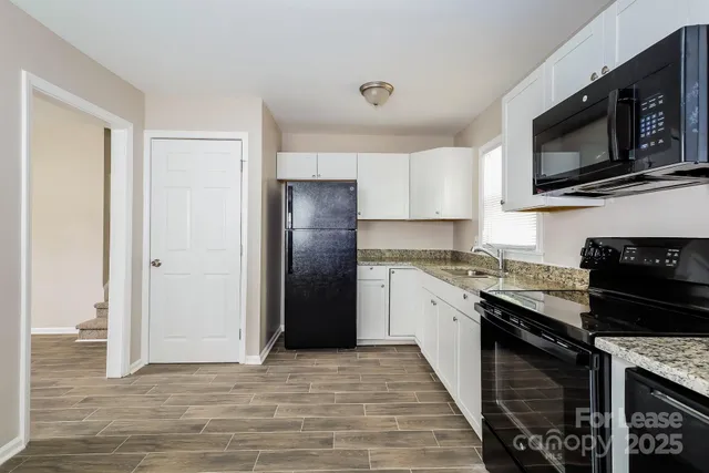 a kitchen with granite countertop a refrigerator stove and microwave