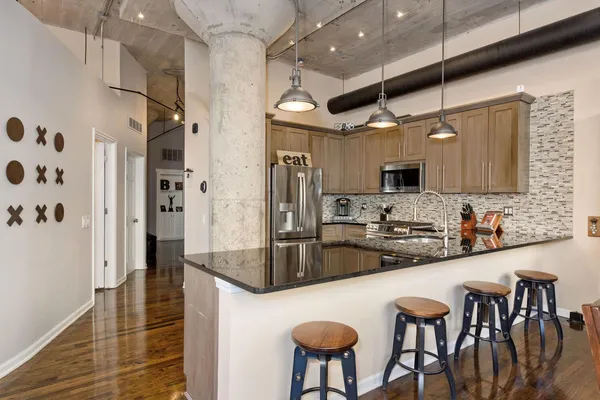 a kitchen with stainless steel appliances granite countertop a sink and a refrigerator