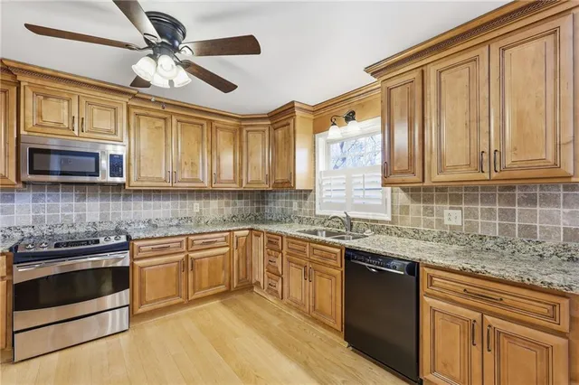 a kitchen with stainless steel appliances granite countertop a stove sink microwave and cabinets