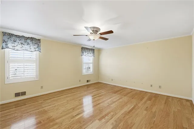 an empty room with a window and a ceiling fan
