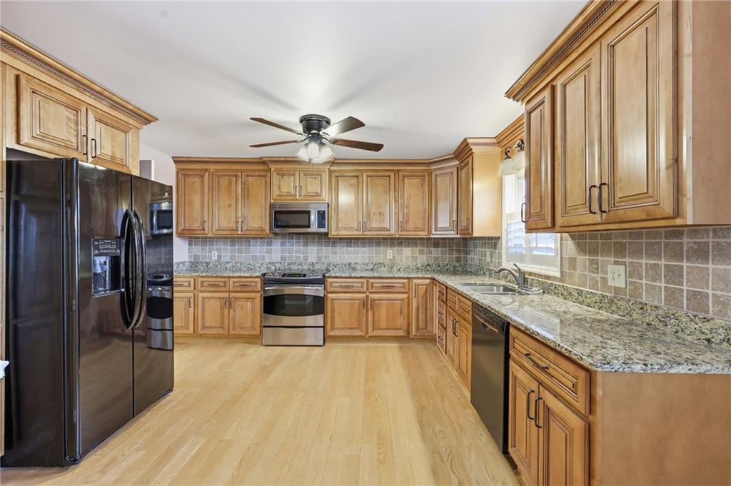 2224 Colonial Drive Gainesville, GA 30501 - Photo 18 of 40 a kitchen with stainless steel appliances granite countertop a refrigerator a sink dishwasher a stove and a dining table with wooden floor