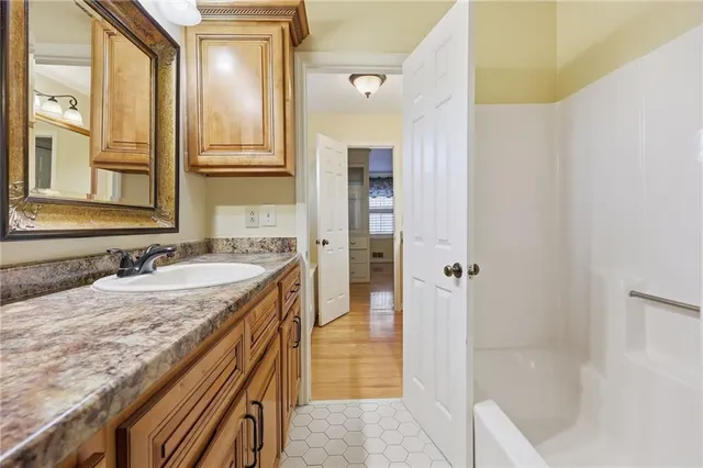 a bathroom with a granite countertop sink and a mirror