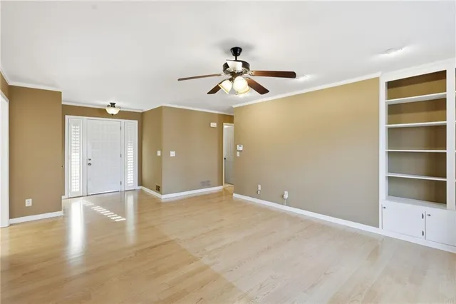 a view of empty room with wooden floor and ceiling fan