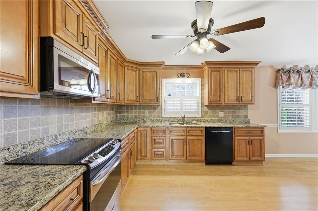 2224 Colonial Drive Gainesville, GA 30501 - Photo 22 of 40 a kitchen with stainless steel appliances granite countertop a stove sink and cabinets