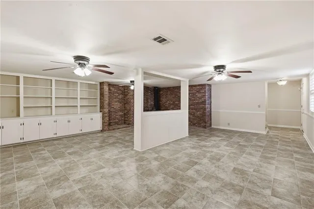 an empty room with windows and cabinet