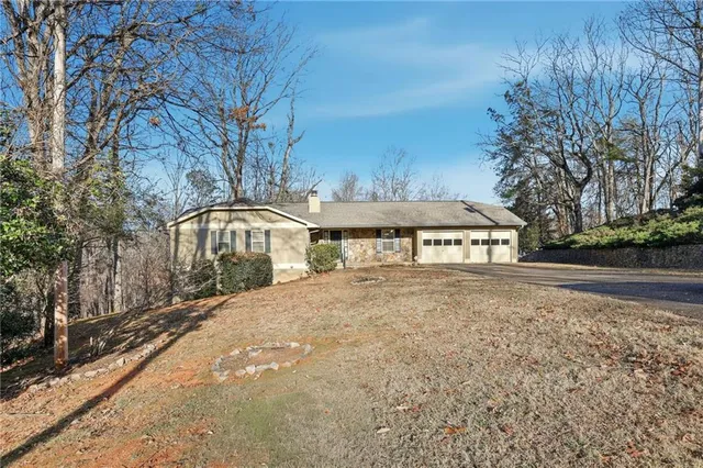 a front view of a house with yard and trees