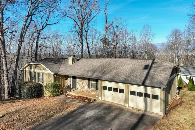a view of a large white house with a yard and large tree