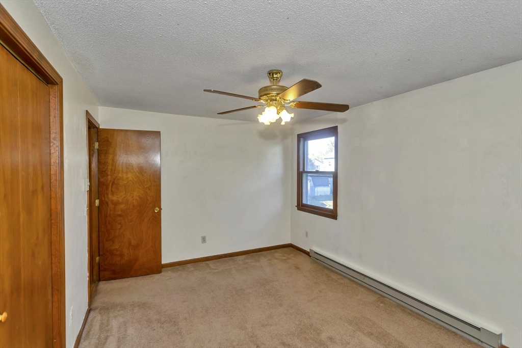 212 Poplar Street Chicopee, MA 01013 - Photo 11 of 22 an empty room with windows and chandelier fan