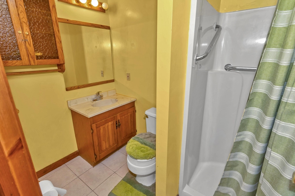 212 Poplar Street Chicopee, MA 01013 - Photo 16 of 22 a bathroom with a sink a toilet a mirror and shower