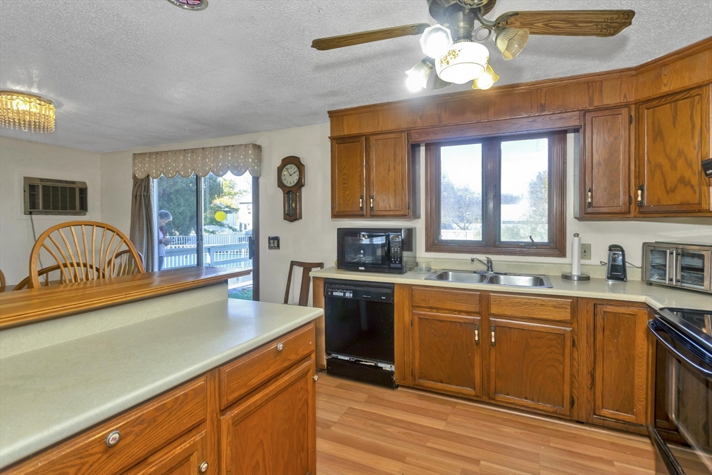 212 Poplar Street Chicopee, MA 01013 - Photo 3 of 22 a kitchen with granite countertop stainless steel appliances a stove cabinets and wooden floor