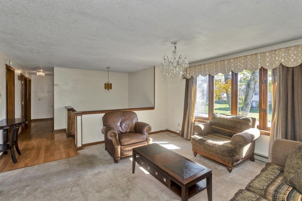 212 Poplar Street Chicopee, MA 01013 - Photo 8 of 22 a living room with furniture and a chandelier