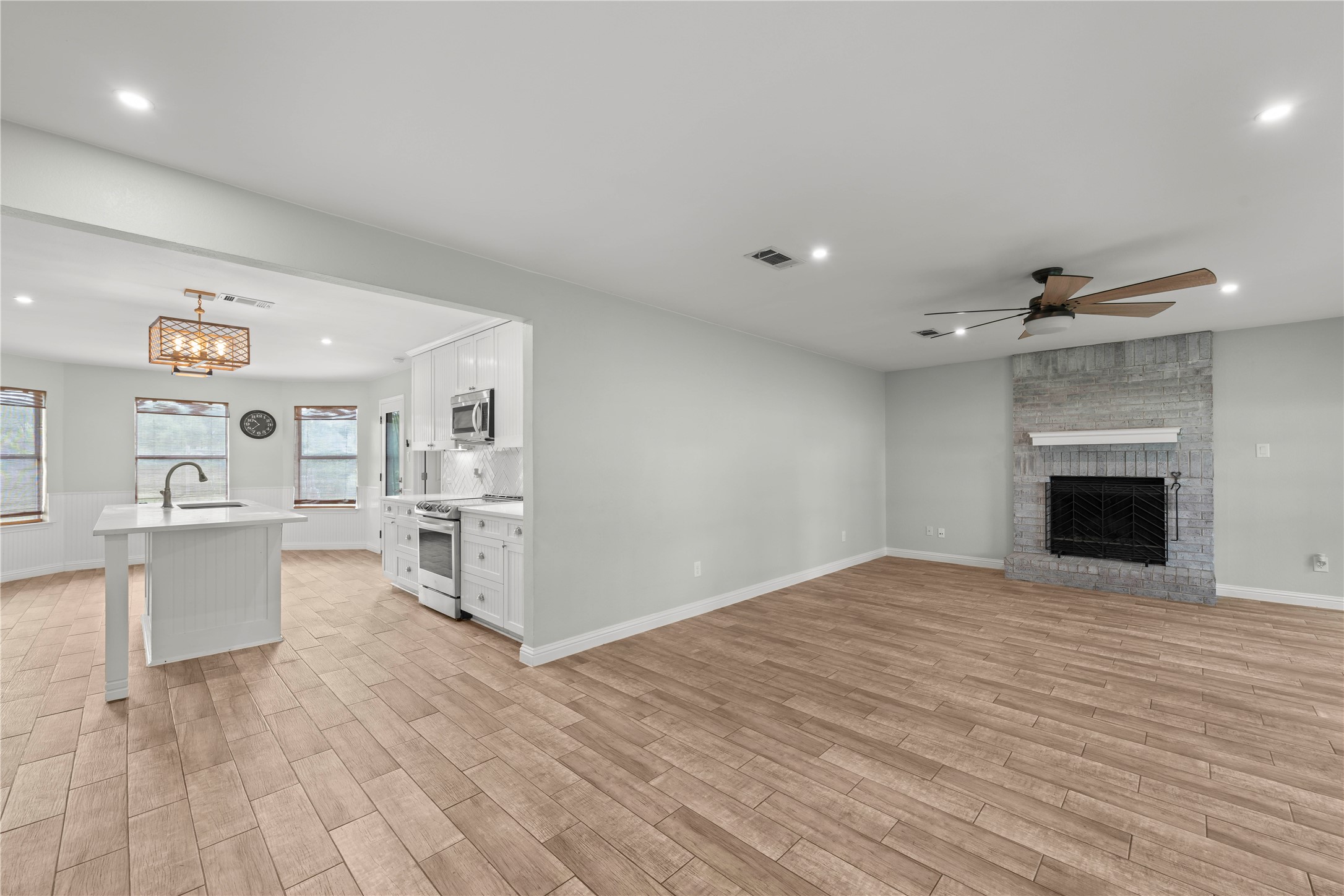 1329 Quail Ravine Round Rock, TX 78664 - Photo 13 of 39 Gleaming wood-look tile floors connect a spacious living room to the adjacent kitchen.
