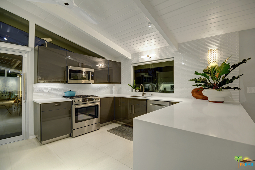 984 East La Jolla Road Palm Springs, CA 92264 - Photo 51 of 53 a kitchen with stainless steel appliances kitchen island granite countertop a stove a sink and a microwave