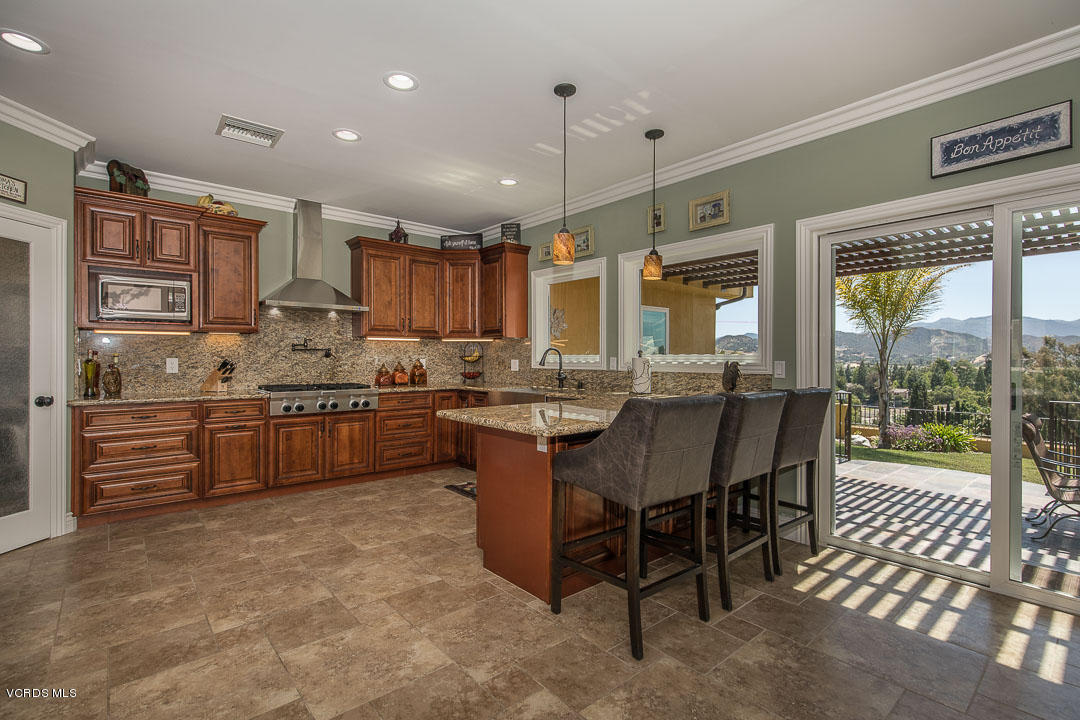 959 Rancho Road Thousand Oaks, CA 91362 - Photo 20 of 57 a kitchen with stainless steel appliances kitchen island granite countertop a table chairs and a sink