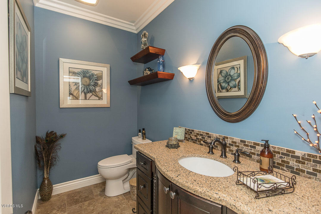 959 Rancho Road Thousand Oaks, CA 91362 - Photo 27 of 57 a bathroom with a granite countertop toilet a sink and a mirror