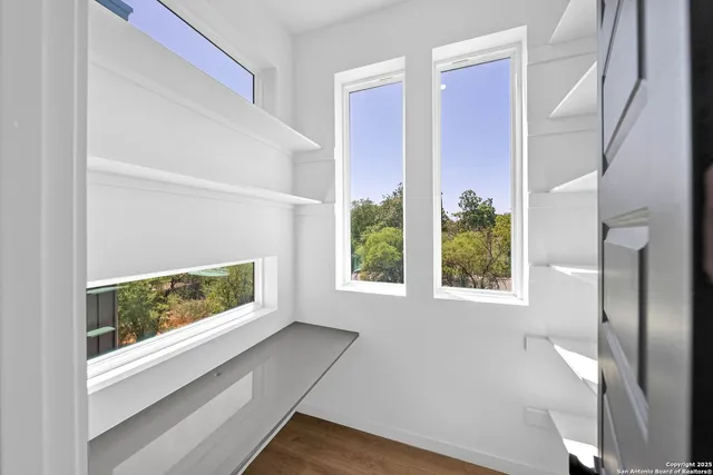 a view of hallway with a large window and wooden floor