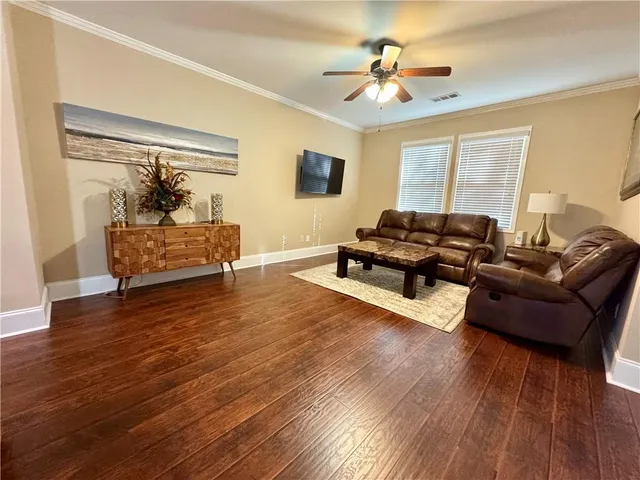 a living room with furniture and a wooden floor