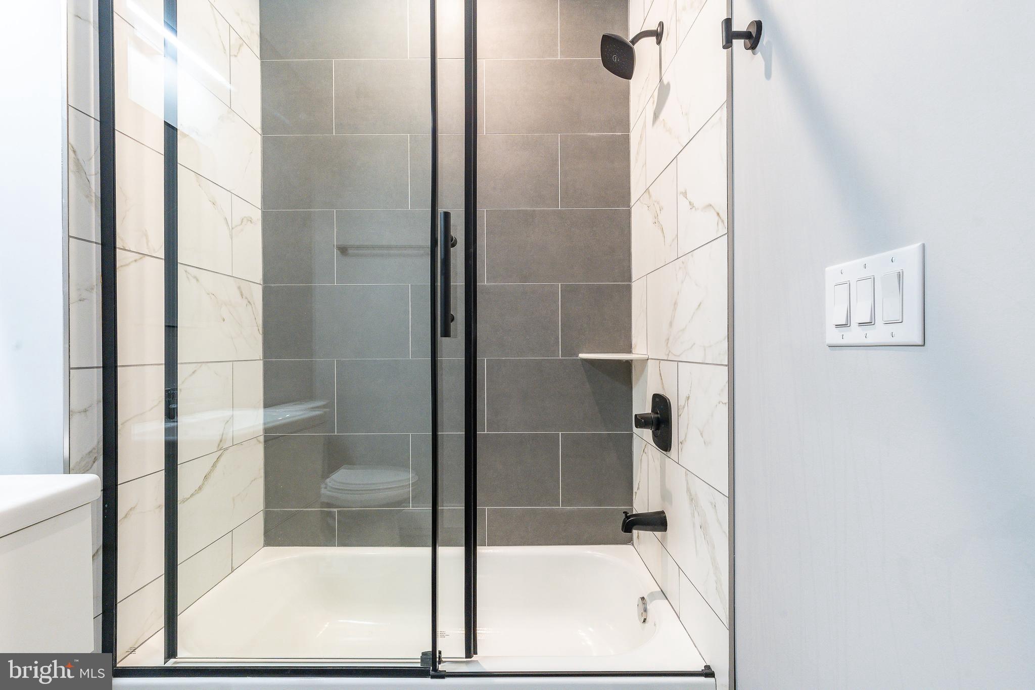 2821 Livingston Street, Unit 2 Philadelphia, PA 19134 - Photo 14 of 24 a bathroom with a glass shower door