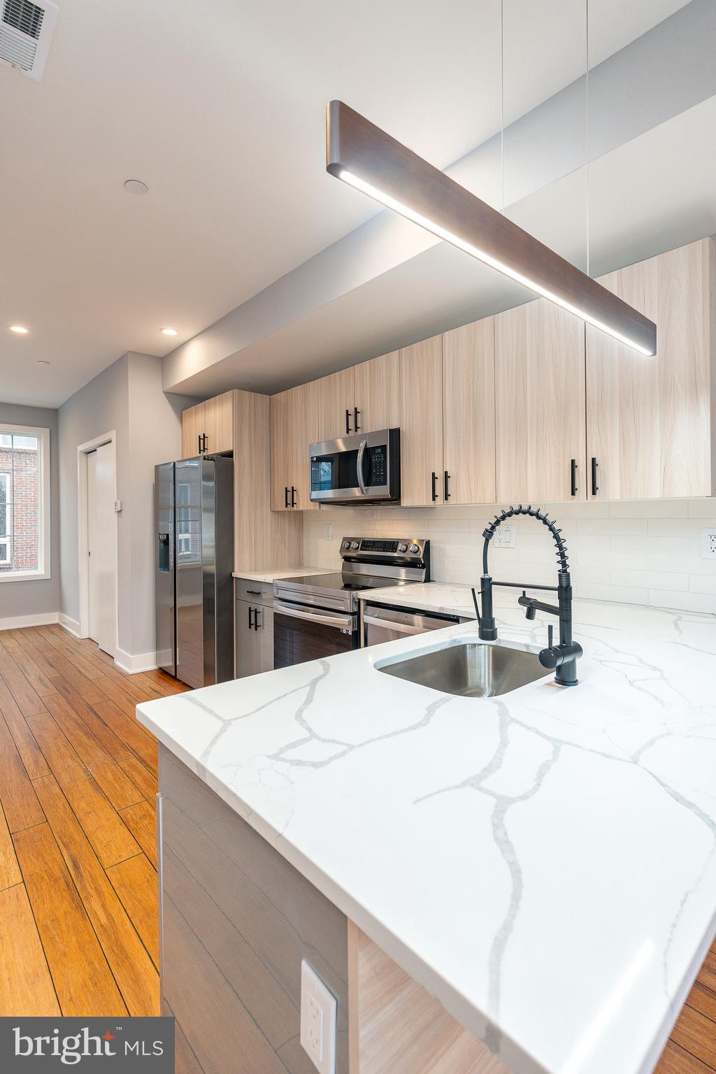 2821 Livingston Street, Unit 2 Philadelphia, PA 19134 - Photo 4 of 24 a kitchen with stainless steel appliances kitchen island sink refrigerator and stove