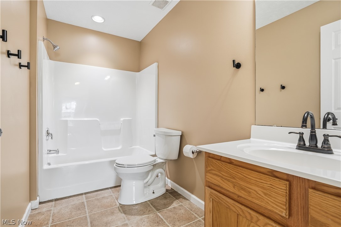3280 Seven Bridges Road Medina, OH 44256 - Photo 36 of 41 Bathroom featuring a wood-finish vanity with a white countertop and integrated sink, a dark bronze-finish faucet, a white toilet, and a white tub/shower combination with a dark bronze-finish showerhead