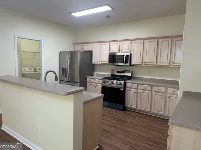 a view of an empty room with wooden floor fireplace and a window