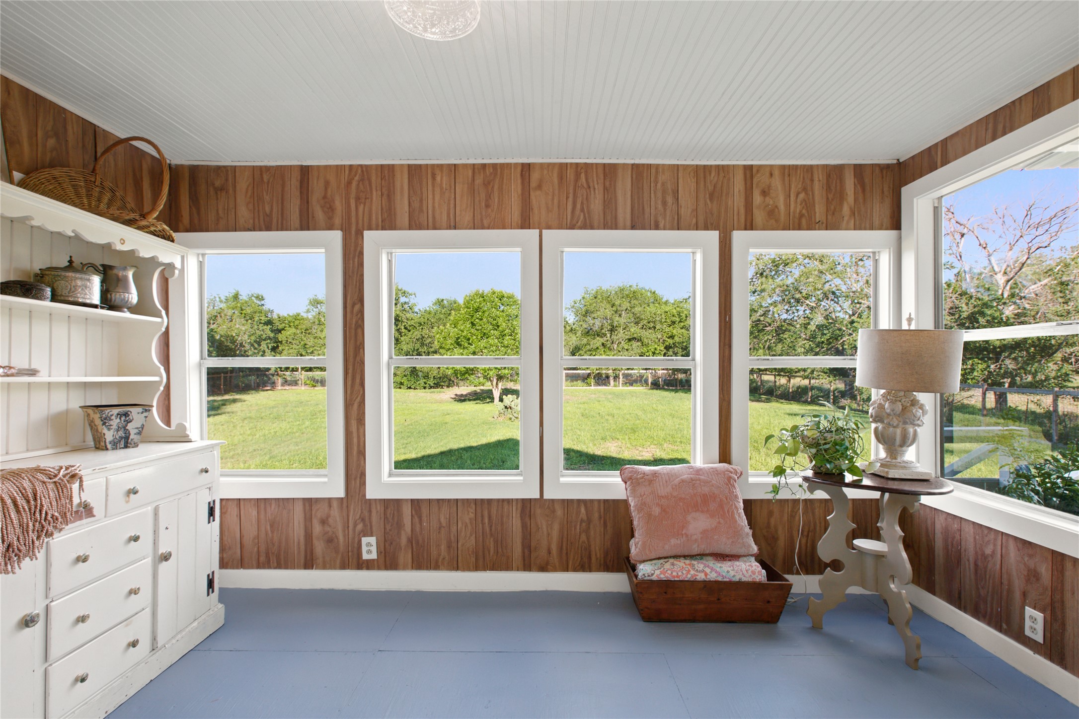 372 Old Lockhart Road Lockhart, TX 78644 - Photo 29 of 40 A well-lit sunroom with beadboard paneling offers sweeping backyard views.