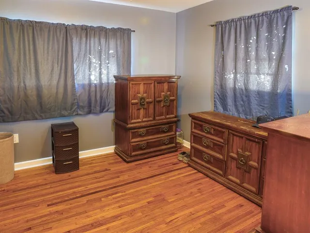 a view of a hallway with wooden floor and closet