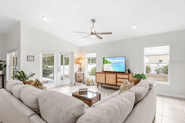 a living room with furniture a large window and a flat screen tv
