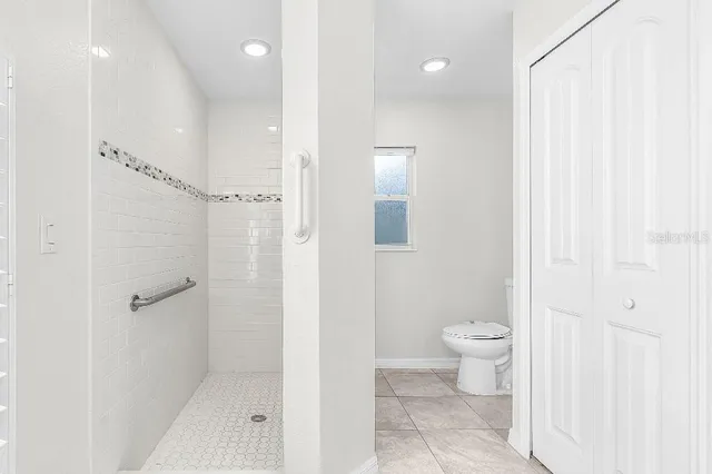 a bathroom with a granite countertop sink a toilet and shower