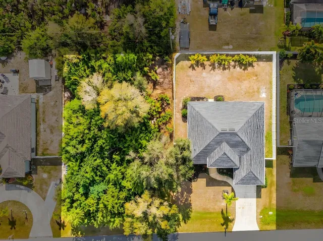 an aerial view of residential house with outdoor space and trees