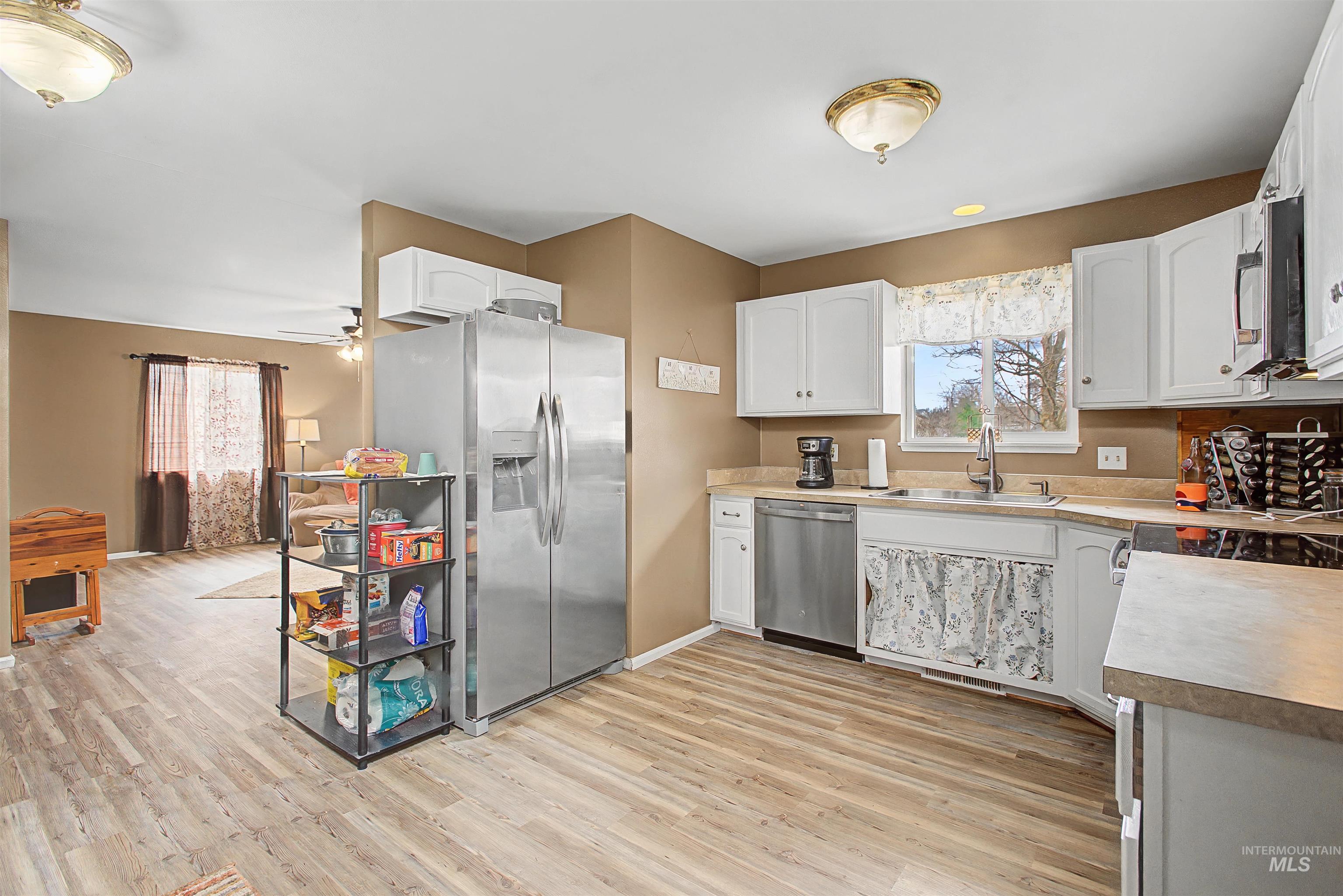 919 9th Street Clarkston, WA 99403 - Photo 12 of 34 Kitchen featuring stainless steel appliances, white cabinets, light countertops, and light wood-style floors