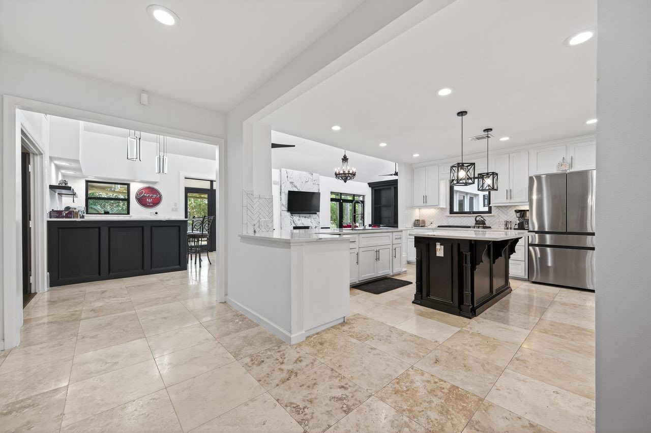 6226 Pebble Beach Drive Houston, TX 77069 - Photo 3 of 46 a large white kitchen with stainless steel appliances kitchen island granite countertop a refrigerator and cabinets