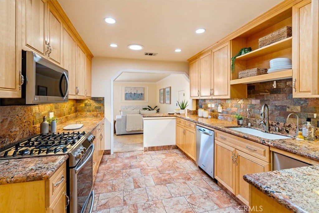 318 Indio Drive Pismo Beach, CA 93449 - Photo 11 of 58 a kitchen with stainless steel appliances granite countertop a stove top oven a sink dishwasher and cabinets with wooden floor