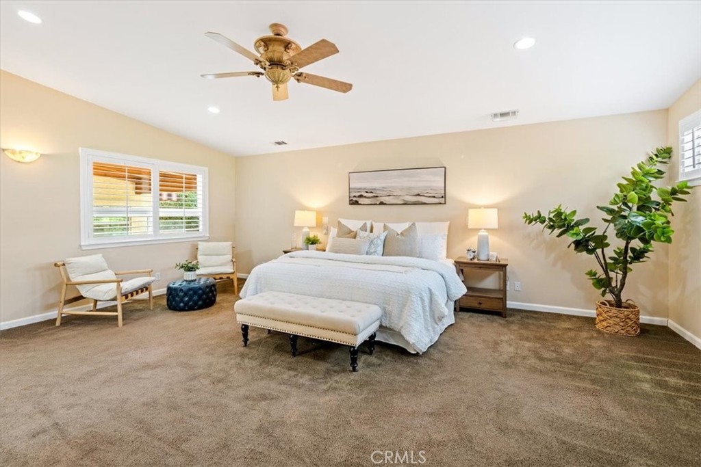 318 Indio Drive Pismo Beach, CA 93449 - Photo 17 of 58 a spacious bedroom with a bed a couch and a potted plant