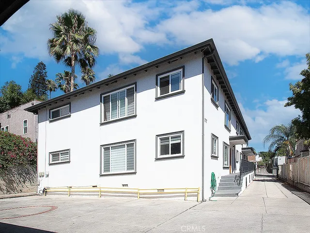 a white house with tree in front of it