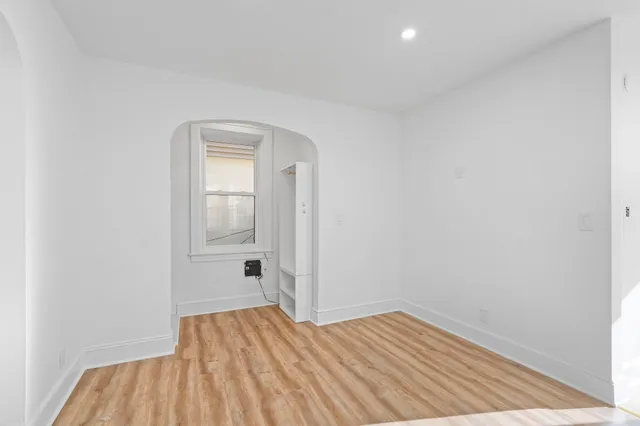 a view of a room with wooden floor and white walls