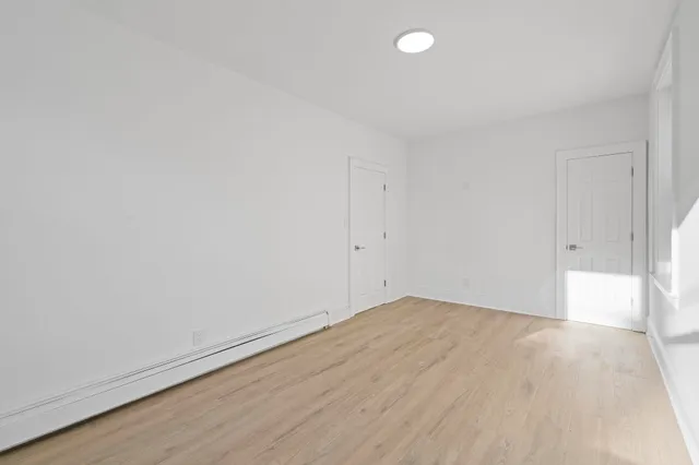 a view of an empty room with wooden floor