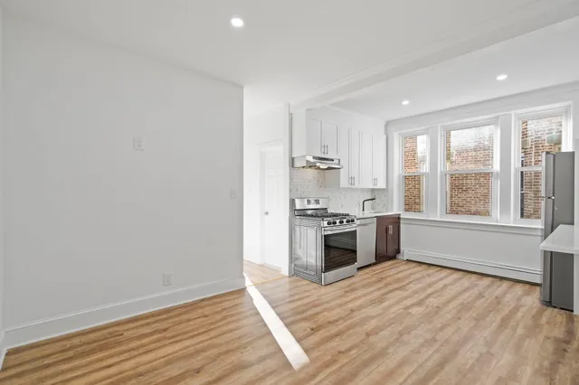 a kitchen with a stove and a white wooden cabinets