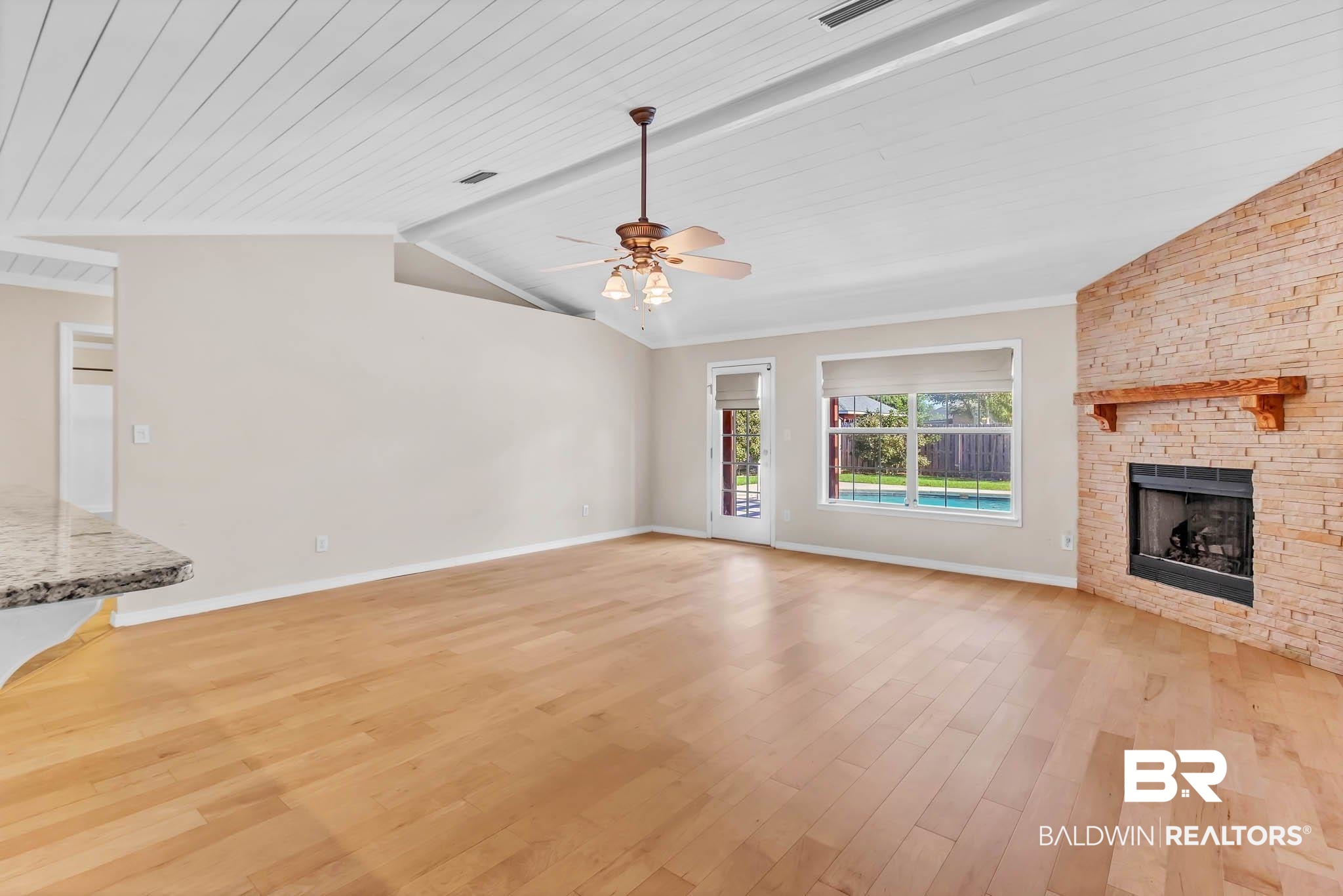 9607 Czar Court Fairhope, AL 36532 - Photo 9 of 42 Unfurnished living room with lofted ceiling, light wood finished floors, a stone fireplace, a ceiling fan, and wooden ceiling