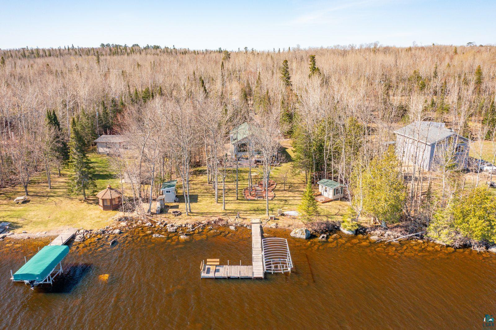 4452 Moccasin Point Road Tower, MN 55790 - Photo 43 of 44 Waterfront property featuring multiple docks, a gazebo, and two structures situated among mature trees