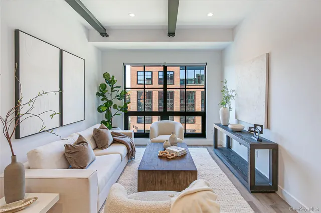 a living room with furniture large window and potted plants