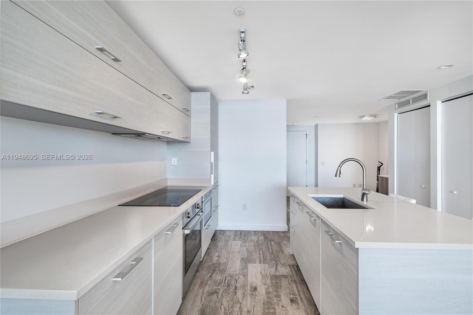 650 Northeast 32nd Street, Unit 4306 Miami, FL 33137 - Photo 11 of 52 a kitchen with a sink and a stove top oven