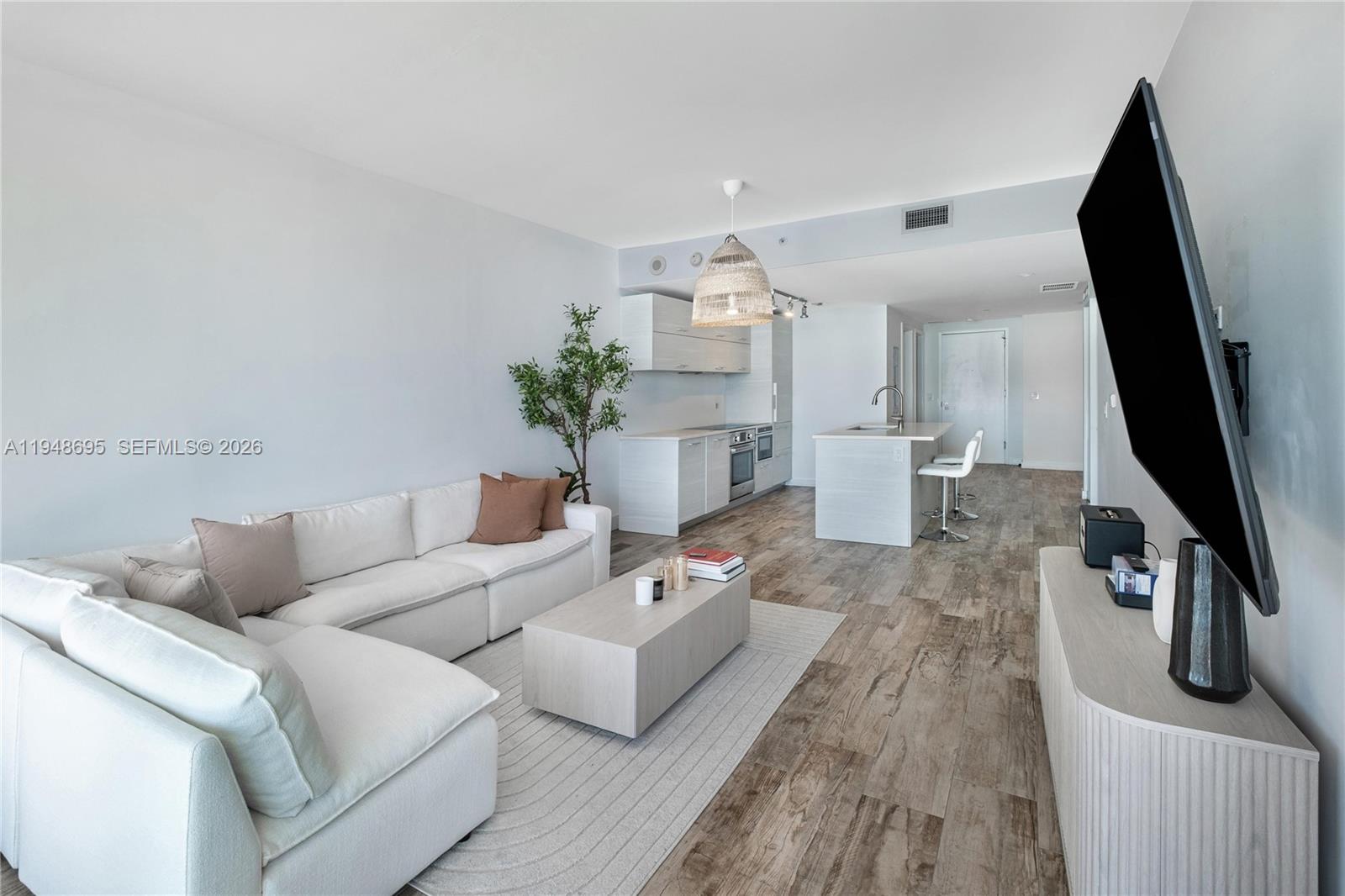 650 Northeast 32nd Street, Unit 4306 Miami, FL 33137 - Photo 7 of 52 a living room with furniture and a flat screen tv