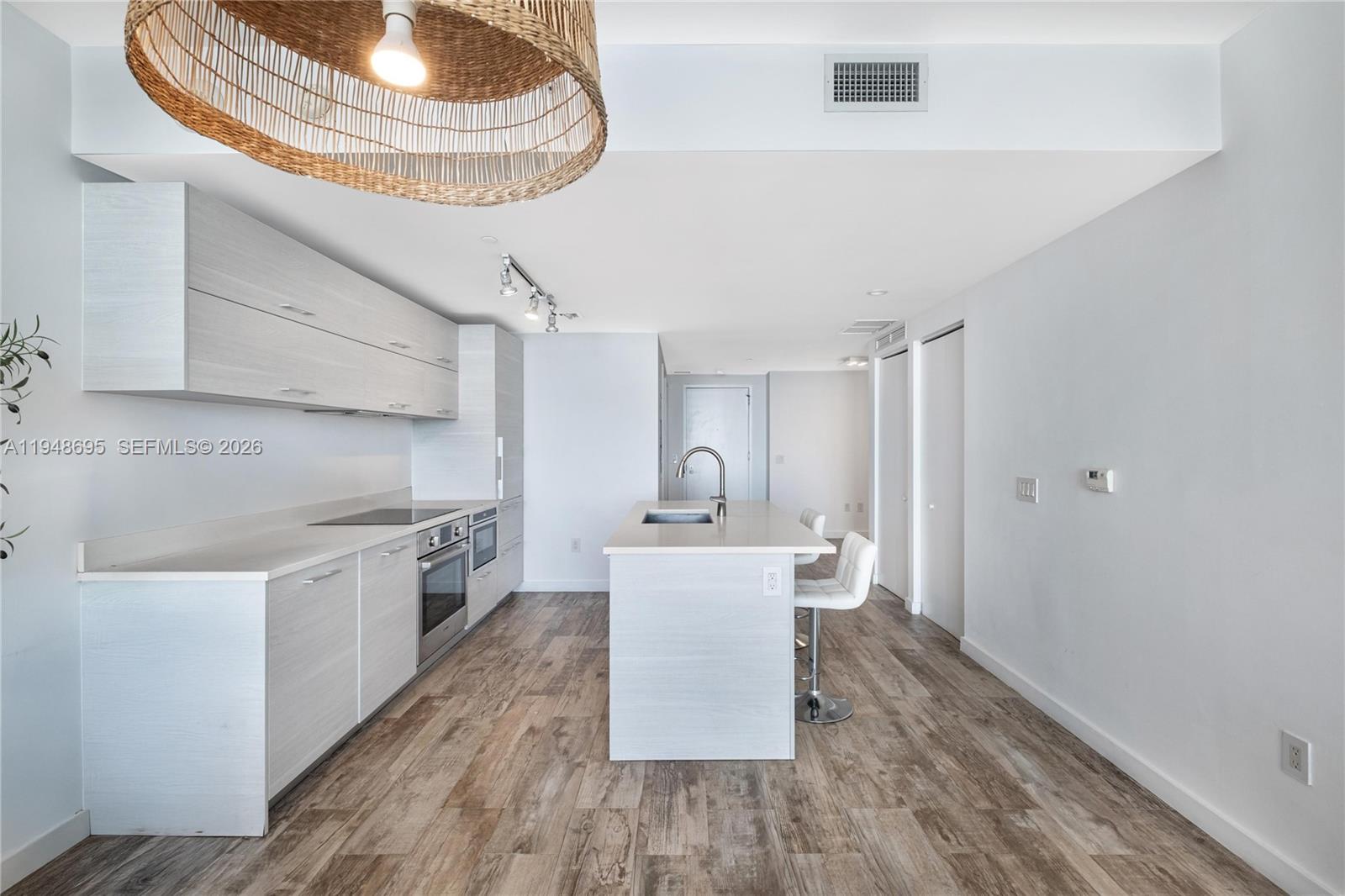 650 Northeast 32nd Street, Unit 4306 Miami, FL 33137 - Photo 9 of 52 a kitchen with a sink a stove cabinets and wooden floor