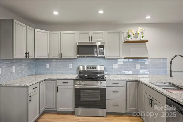 a kitchen with white cabinets stainless steel appliances and sink