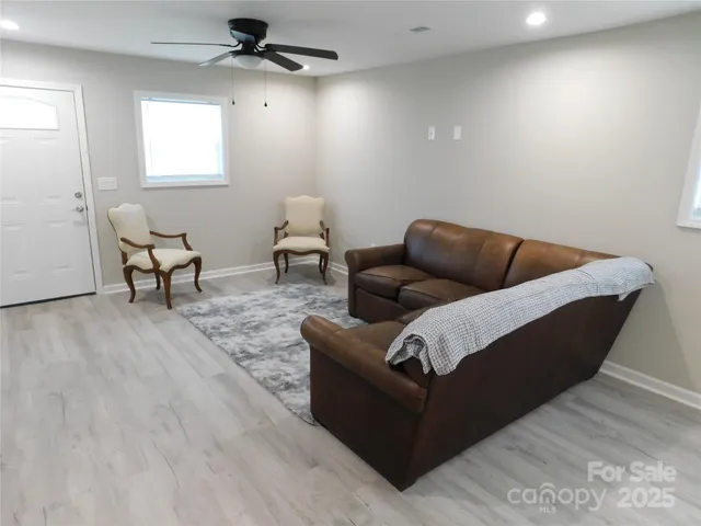 a living room with furniture and a dining table with rug